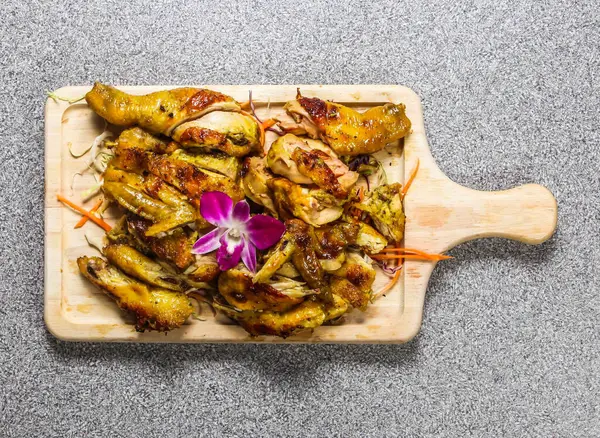 stock image barbecued chicken with leg, thigh, wings, and breast piece chilli sauce served on wooden bard isolated on grey background top view of hong kong fastfood