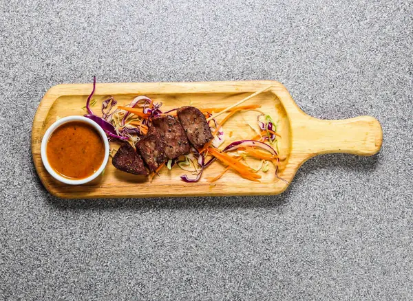 Biftek dili bbq satay ve kırmızı biber sosu Gri arka planda izole edilmiş ahşap ozan üzerinde servis edilir Hong Kong fast food 'un üst görüntüsü
