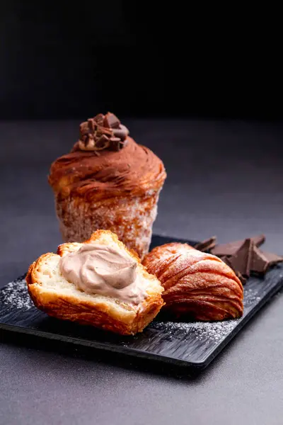 stock image Chocolate puff pastry waffles with vanilla cream, fork served in dish isolated on dark background side view of baked cafe food