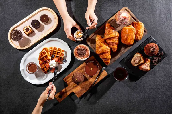 stock image assorted cafe baked food variety Plain Croissant, chocolate pastry puff, CACAO Crispy Waffles, cacao tofu, Chocolate Puff, chocolate tart, with fork served isolated on dark background top view