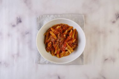 Penne Amatriciana makarnası ve domates sosu gri arka planda izole edilmiş İtalyan fast food manzarası.