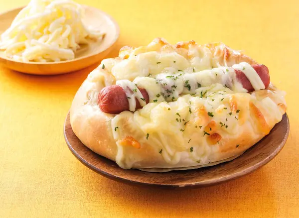 stock image Cheese sausage buns served on wooden board isolated on orange background side view of hong kong cafe baked food dessert