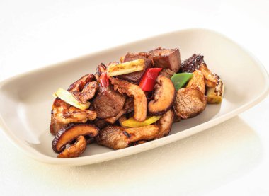 Rice Cake Kızarmış Biftek filetosu ile XO sosu, mantar ve kapsicum Hong Kong yemeğinin arka planında yalıtılmış olarak servis edilir.