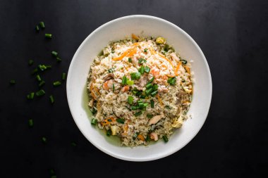 Karides, karides, karides, tavuk, yumurta, havuç ve taze soğanlı özel karışık pirinç Çin yemeğinin arka planında izole edilmiş olarak servis edilir.