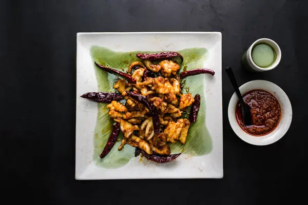 stock image Spicy Red Pepper Cuttlefish with red and green chilli paste sauce served in dish isolated on dark background top view of chinese food