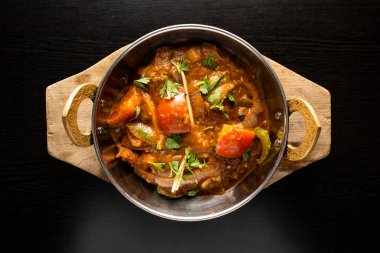 Jalfrezi tavuğu arasında domates, soğan, zencefil ve kişniş, izole edilmiş koyu arka planda Hint baharatları, bangladeş ve Pakistan yemekleri bulunmaktadır.