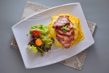 Bal jöleli domuz omleti ve salatalı pilav peçetenin üstünde gri arka planda Çin yemeğinin üst görüntüsünde servis ediliyor.