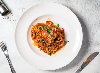 Baharatlı spagetti, marinara, deniz ürünleri, karides, kalamar kalamar ve domates sosu arka planda izole edilmiş İtalyan yemeği manzarasında servis edilir.