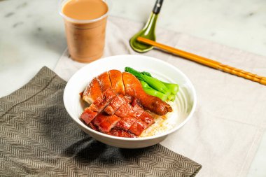 BBQ Pork ve Soya Tavuk Bacağı ile sütlü kopi çubukları ve kaşıkla servis edilen kaşık peçete tarafında mermer arka planda Hong Kong yemeği izole edilmiş.