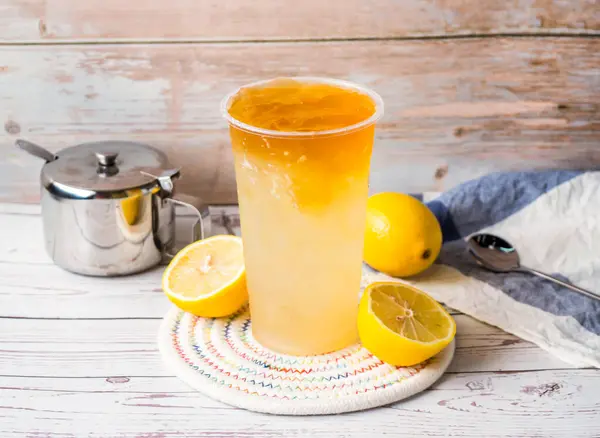 Stock image Iced lemon love jadeor or Lemon Aiyu tea with sugar pot and spoon served in disposable glass isolated on table side view of hong kong tea