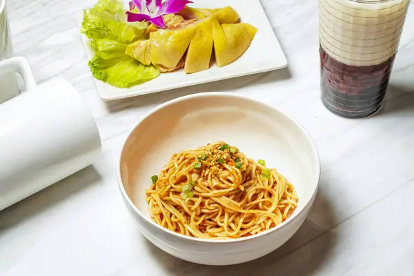 Stock image Huadiao tender chicken and sesame noodles with Taiwanese red bean ice tea served in dish isolated on marble background side view of taiwan food