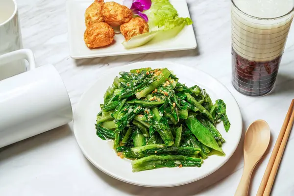 Stock image Stir fried Acai, baby kailan or chinese broccoli Fried squid balls, Taiwanese red bean ice tea served in dish isolated on marble background side view of taiwan food