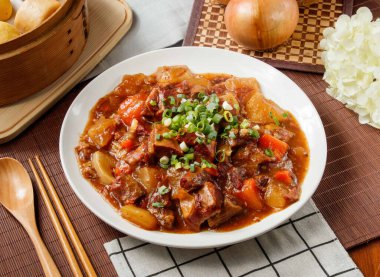 Sebzeli sığır güveci, domates, yeşil soğan, patates, Tayvan yemeği masasının kenarında yalıtılmış.