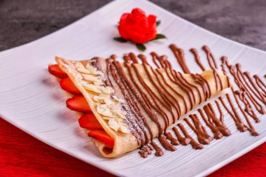 Çilekli Çilekli Çilekli Çilekli Çilekli Krep. Masanın kenarından izole bir şekilde servis ediliyor.