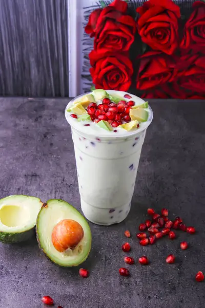 stock image Avocado Pomegranate Smoothie Delight topped with a generous serving of avocado slices and pomegranate seeds served in glass isolated on background side view of healthy and delicious beverage