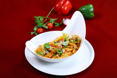 penne arrabiata pasta topping with coriander, capsicum and tomato sauce served in dish isolated on red background side view of italian food clipart