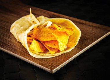 Umman Çıtır Cips Paratha Roll shawarma dürümü ahşap tahtada izole edilmiş fast food yan görüntüsü