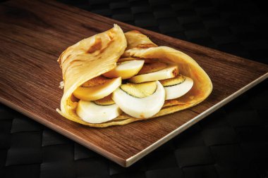 Haşlanmış Egg Paratha Roll shawarma dürümü tahtadan izole edilmiş. Oman 'ın fast food yan görüntüsü.