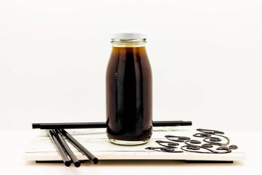 Soğuk Americano Kahvesi, beyaz arka plandaki soğuk içeceklerin ahşap tahta tarafında izole edilmiş cam bir şişede servis edilir.