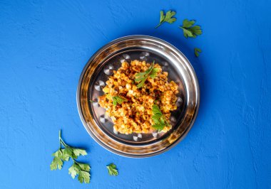 Meksika usulü ızgara mısır çekirdeği ile Chili, limon ve kişniş servis edilir. Mavi arka planda servis edilir. Baharatlı ızgara vejetaryen atıştırmalığının üst manzarası.