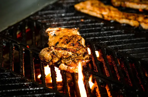 stock image Grilling Chicken on the Grill with Flames and fire live bbq side view of a mouthwatering delicious meal