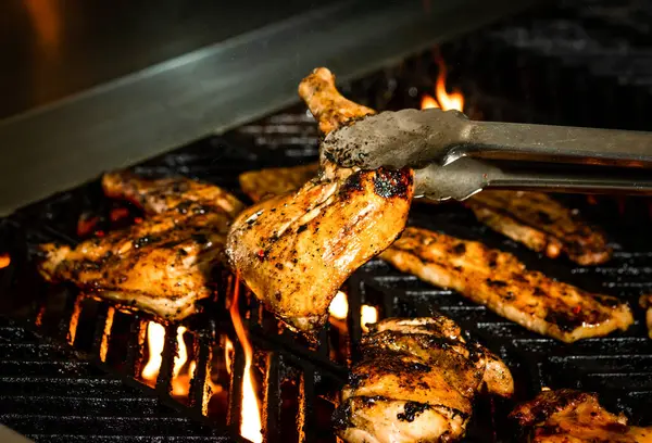 stock image Sizzling Mixed Grill with Chicken, Bacon, pork belly strips, and Flames on the hot grill closeup side view live grilling