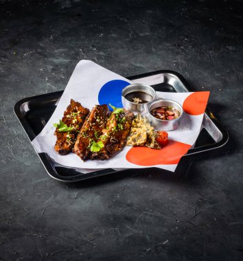 Sos soslu Hickory Bbq Biftek Göbeği A la kart yiyecek tabağının gri arka plan görünümünde izole edilmiş tepside servis edilir.