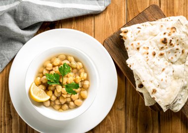 Nakhaj or Spicy Chickpeas with pita bread served in plate isolate on wooden table top view of arabic food clipart