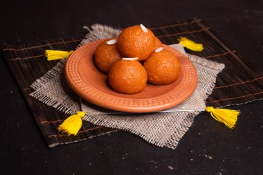 Motichoor Laddu ya da gulab jamun, Bangladeş, Hindistan ve Pakistan tatlılarının arka planında izole edilmiş kil tabakta servis edilir.