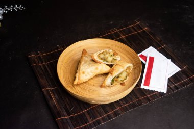 Sebze Samosa veya Samucha, Bangladeş fast food 'un arka planında izole edilmiş ahşap tabakta servis edilir.