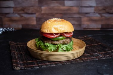 Klasik sığır Burger 'i arasında domates, soğan, marul izni ve bangladeş fast food' un arka planında izole edilmiş ahşap tabakta servis edilen kapsiyum yer alıyor.