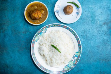 Yumurtalı sade pirinç ve alu bhorta gri arka planda bangladeş yemeğinin üst manzarasında servis edilir.