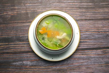 Sebzeli tavuk çorbası lahana, havuç ve biberli çorba, ahşap masa üzerinde yalıtılmış çorba ve Tayland yemeği.