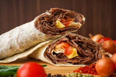 Biftek Yiyici Shawarma 'yı ahşap masaya hapsetti. Arap ve Türk sokak yemeklerinin yan görüntüsü.