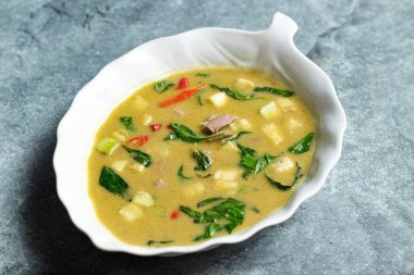 Tayland yemeğinin gri arka planında servis edilen patates, ot ve kırmızı biberli biftek.