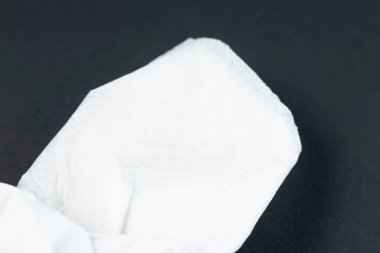 Katlanmış beyaz peçete veya kağıt mendil resmi bir yemek masasının siyah arka plan görünümünde izole