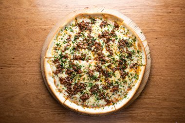 Bolonez Pizzalı biftek ve eritilmiş peynirle kaplı tahta tahtada servis edilen İtalyan kuzenin arka planında izole edilmiş.