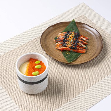 KING CRAB CHAWANMUSHI with ikura, salmon roe and edamame served in plate isolated on napkin side view of Japanese food on white background clipart