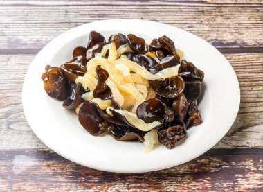 Bulut Kulağı Denizanası veya Kızarmış Ağaç Kulak Mantarı Hong Kong yemeklerinin ahşap masa manzarasında servis edilen tabakta servis edilir.