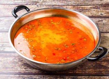 İmza Haydut Çorbası ya da Baharatlı Sichuan Hot Pot Çelik kapta servis edilen acı biberli Hong Kong yemeğinin ahşap masa manzarasında izole edilmiş.