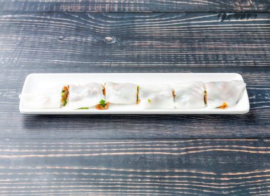 Çin usulü ızgara domuz sosisi tepside servis edilir. Tahta masa başında Hong Kong yemeği manzarası var.