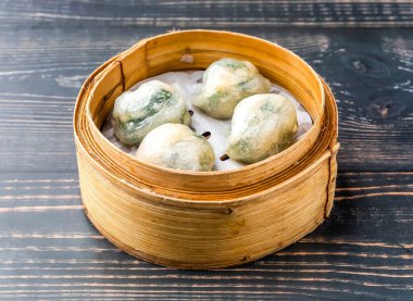 Buharda karides ve sebzeli börek bambu buharlı buharlı tencerede servis edilir. Tahta masa başında Hong Kong yemeği manzarası izole edilir.