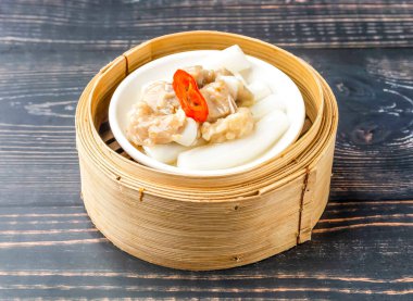 Buharda pilav ve bambu tenceresinde servis edilen pirzola Hong Kong yemeğinin ahşap masa manzarasında izole edilmiş.