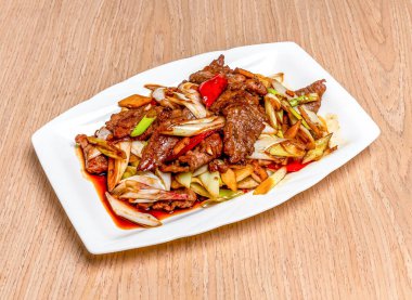 Stir fried beef and welsh onions served in tray dish isolated on wooden table side view of hong kong food clipart