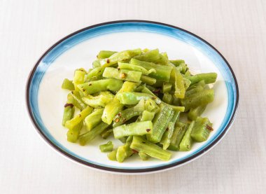 Soğuk anma sebzeleri, Hong Kong yemeklerinin beyaz arka planında izole edilmiş kasede servis edilir.