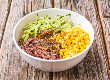 Tütsülenmiş toynaklar soğuk erişteler soğuk erişteler, doğranmış salatalıklar ve tahtadan masa başında servis edilen tahtadan yapılmış mısır taneleri Hong Kong yemeği manzarası.