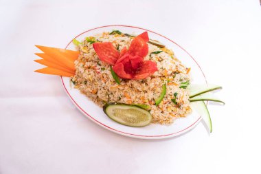 Çin sebzeli yumurta pilavı havuç, salatalık domates ve kapsiyum da dahil olmak üzere beyaz arka planda Tayland ve Bangladeş yemeklerini üst planda izole edilmiş beyaz tabakta servis edilir.