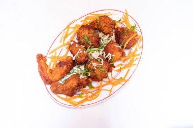 Tayland usulü kızarmış tavuk üzerine havuç ve kişniş dilimi beyaz arka planda izole edilmiş beyaz tabakta servis edilir Tayland mutfağı ve Bangladeş yemekleri.