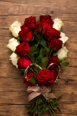 Kırmızı ve beyaz güllerle süslenmiş romantik gül buketi sıcak ve romantik bir ortam yaratıyor izole edilmiş ahşap yüzey manzarası.