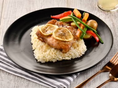 Pilav ve salata ile servis edilen tavuk Al Forno tahtadan masa başında İtalyan fast food manzarası.